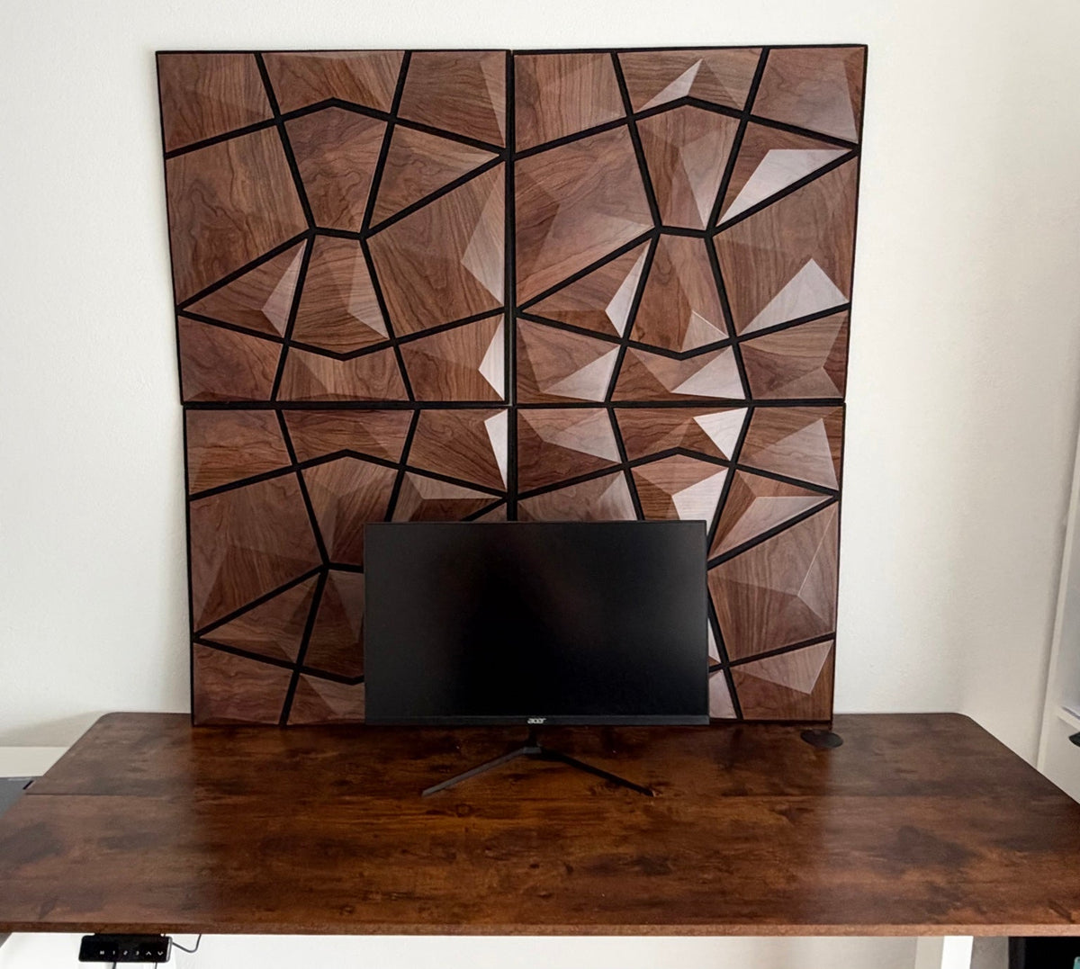 Echtes Setup: 4 AURVEX-Wandpaneele in Dark Oak über einem höhenverstellbaren SONNI-Schreibtisch mit weißem Gestell